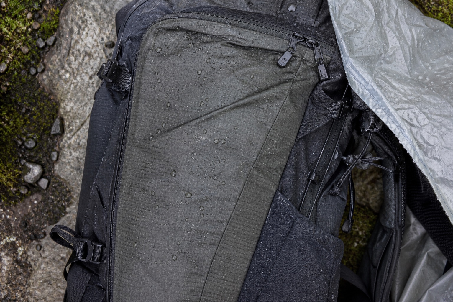 Close-up of backpack seams zips fabric and rain cover edge in wet weather